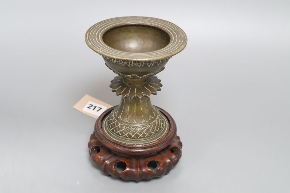 A 19th century Himalayan bronze urn, on carved stand, height 18cm